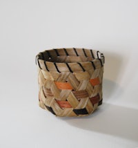 a small basket made out of rattan on a white surface