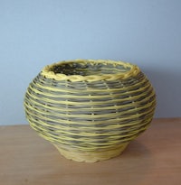 a yellow wicker basket on a wooden table